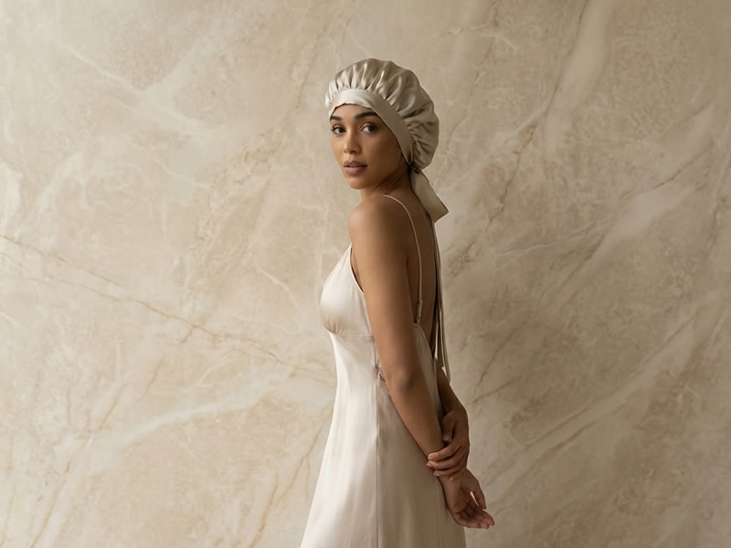 Donna con cuffia di seta per proteggere la piega perfetta. Cura dei capelli, accessori per capelli in seta.