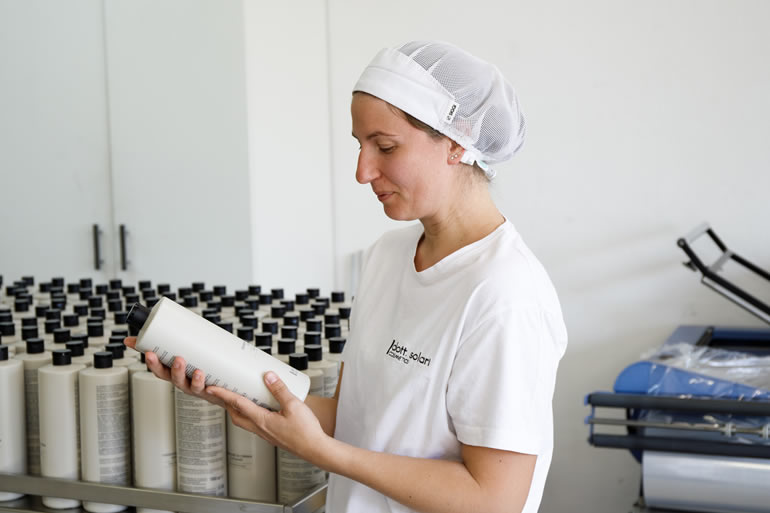 Claudia Solari, membro dello staff, esamina un flacone di cosmetico Dott. Solari. Lavorazione e controllo qualità.
